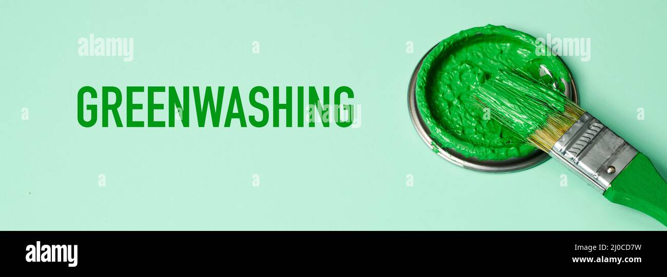 un pennello con vernice verde e il testo greenwashing su sfondo verde, in formato panoramico da utilizzare come banner web o intestazione Foto Stock