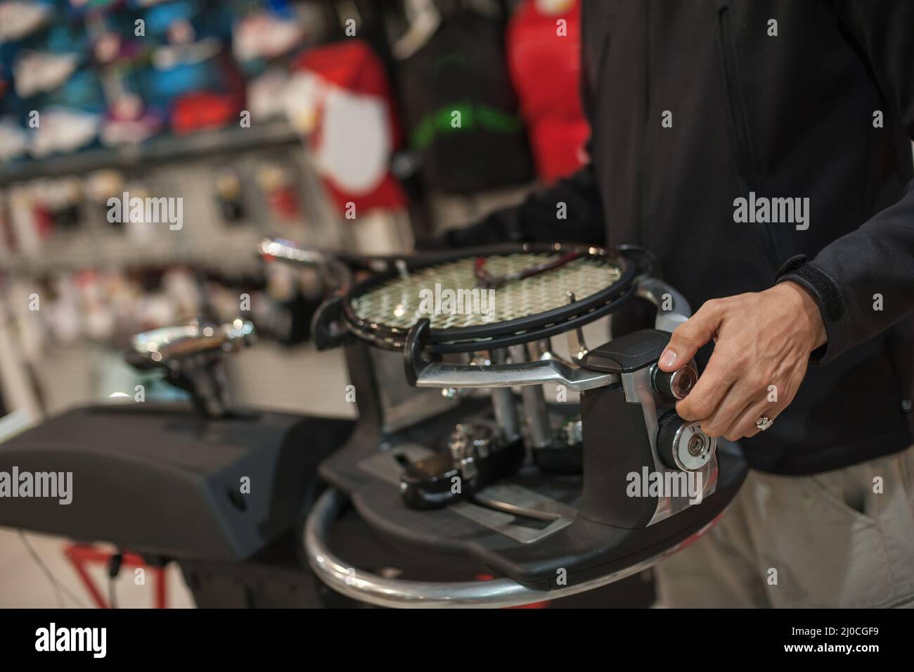 Stringing macchina. Tennista che fa il racket che stringe nella sua officina Foto Stock