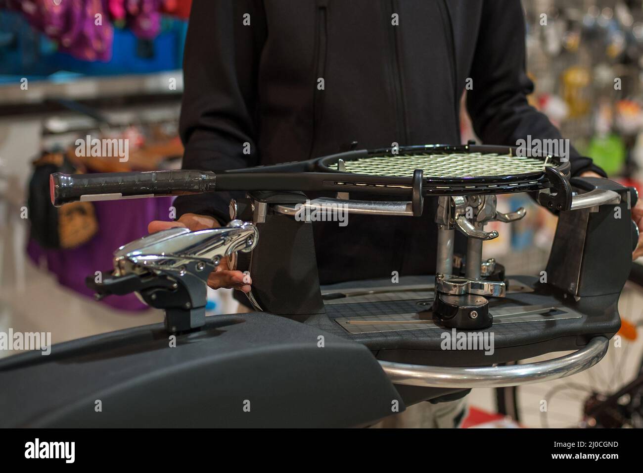 Stringing macchina. Tennista che fa il racket che stringe nella sua officina Foto Stock
