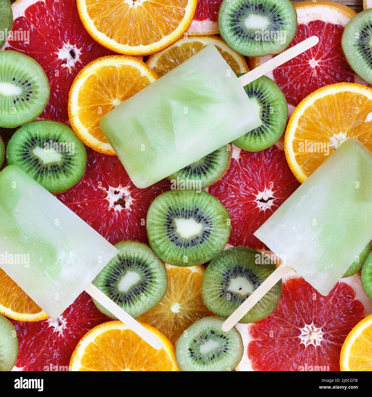 Ghiaccio di frutta. Kiwi vaniglia yogurt popsicli su uno sfondo di lobi di frutta. Foto Stock