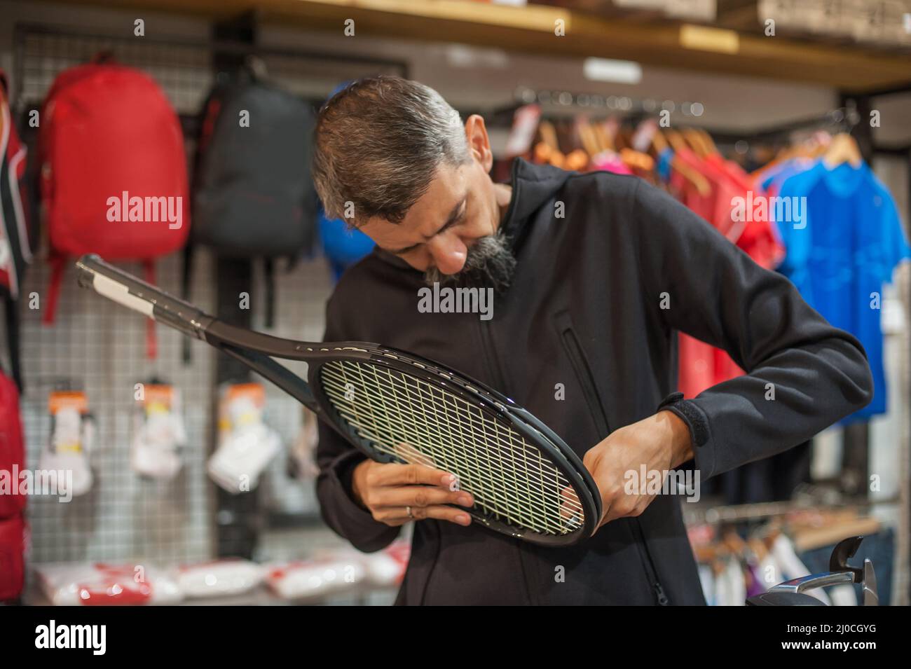 Stringing macchina. Tennista che fa il racket che stringe nella sua officina Foto Stock