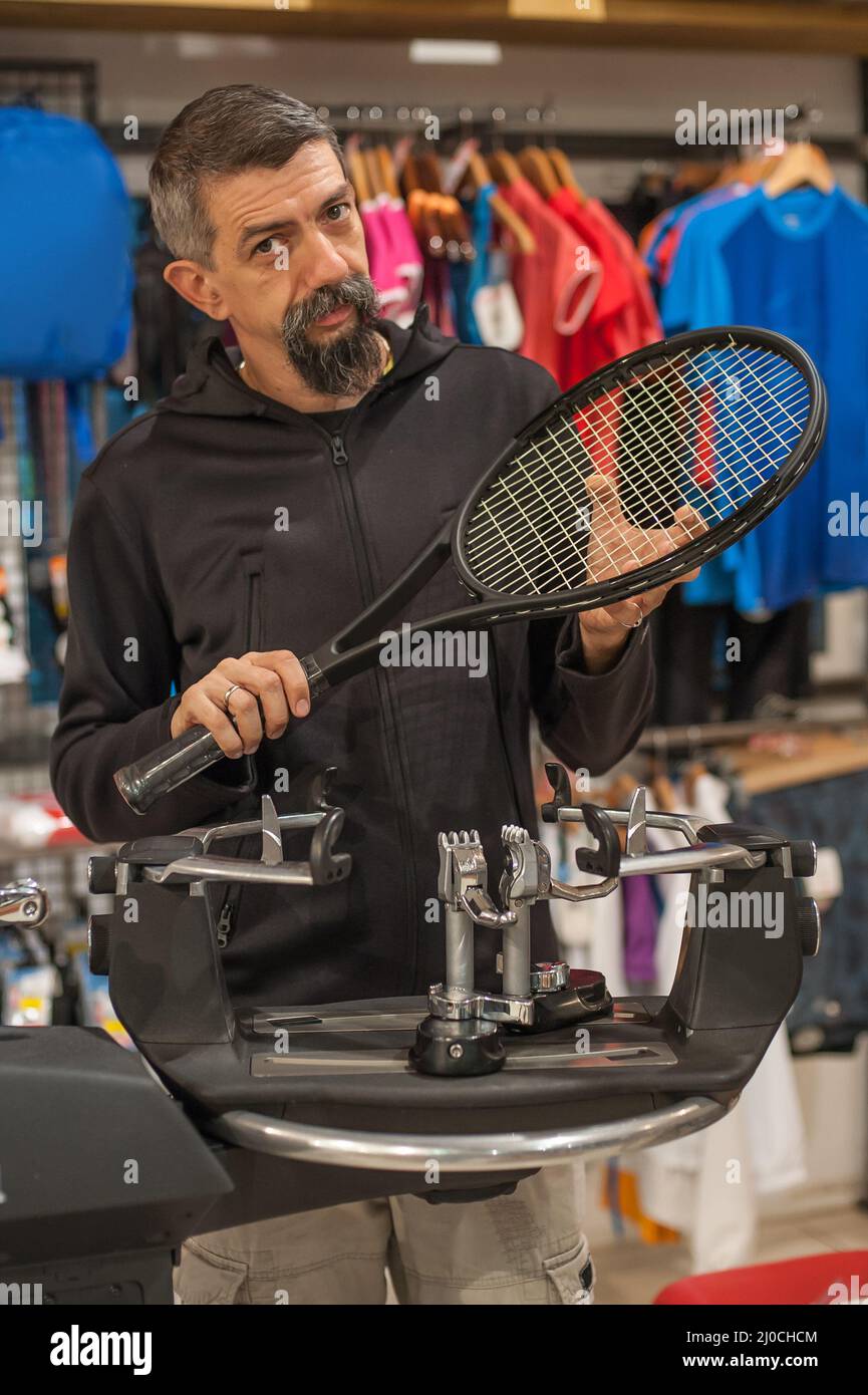 Stringing macchina. Tennista che fa il racket che stringe nella sua officina Foto Stock