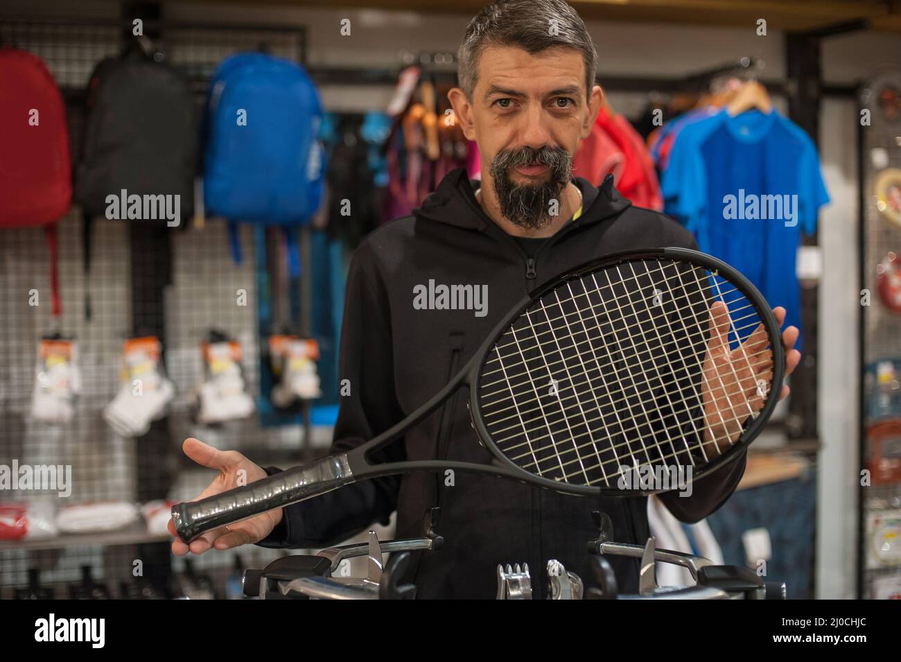 Stringing macchina. Tennista che fa il racket che stringe nella sua officina Foto Stock