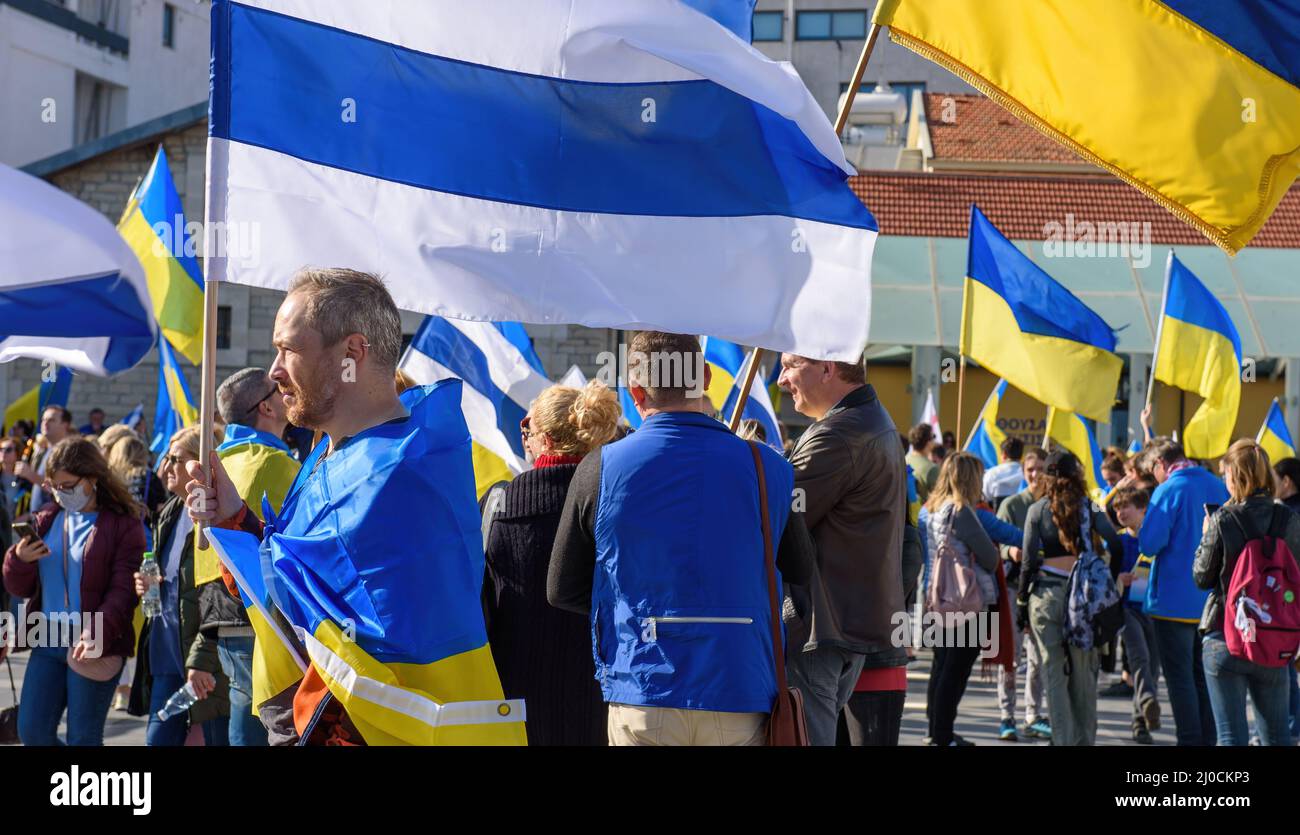 LIMASSOL, CIPRO - 5 MARZO 2022: Uomo che detiene la bandiera bianca blu-bianca anti-guerra russa su un raduno a sostegno dell'Ucraina Foto Stock