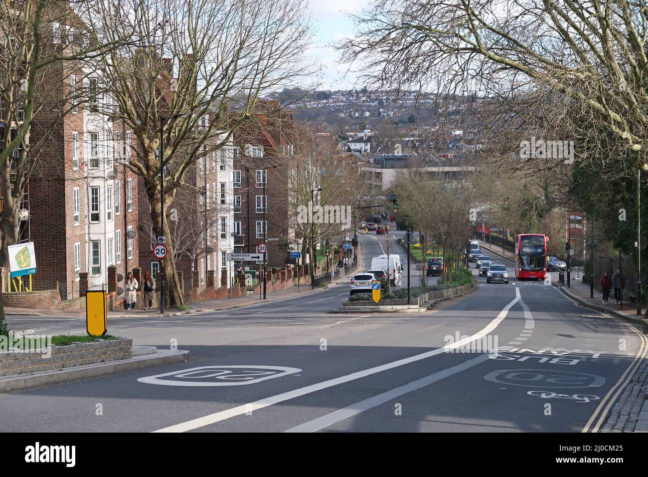 Vista a sud lungo Dog Kenel Hill a East Dulwich, Londra, Regno Unito. Mostra la corsia dell'autobus, i segnali di limite di velocità 20mph e i blocchi di alloggiamento pubblici (a sinistra) Foto Stock