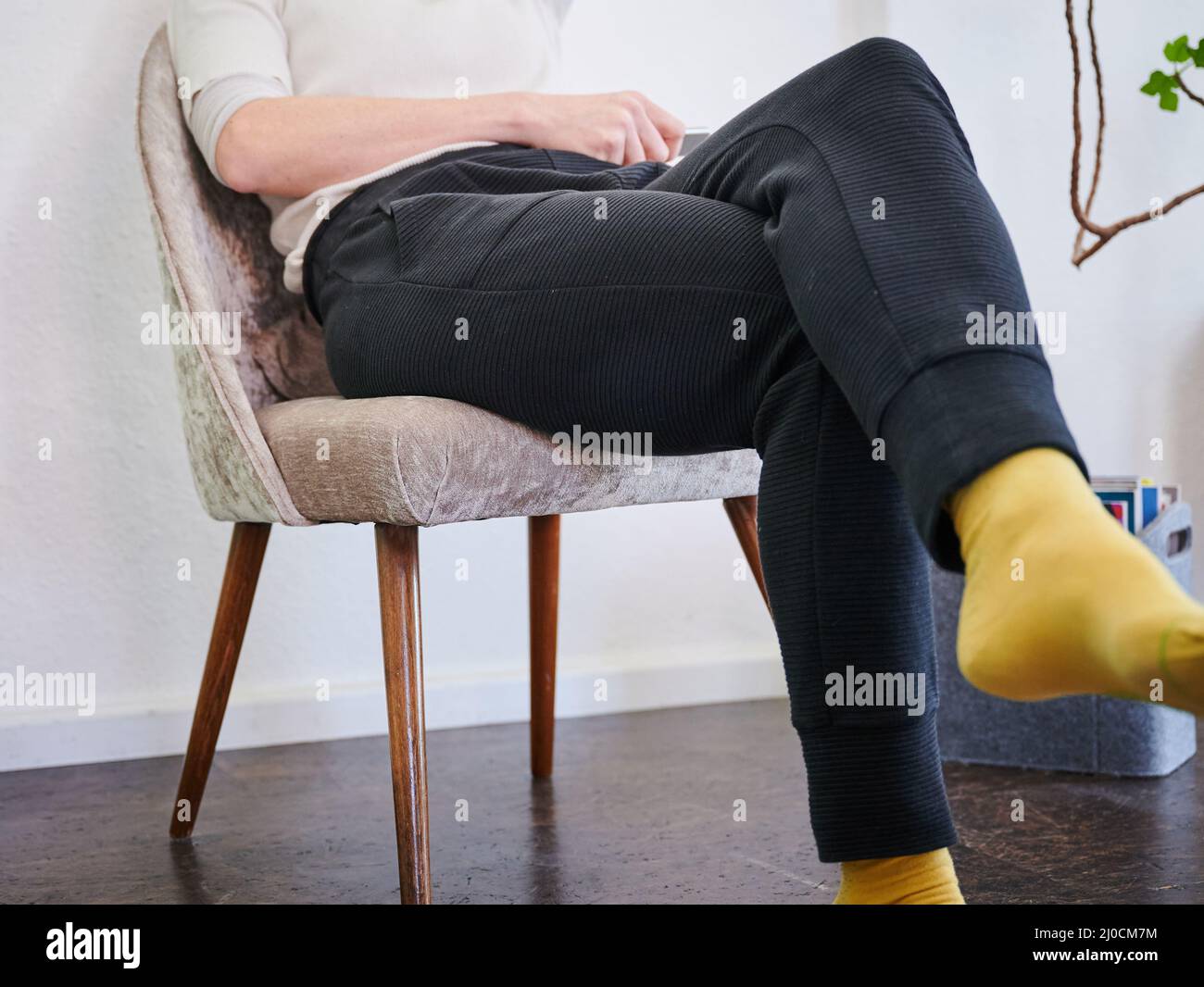 ILLUSTRAZIONE - 07 marzo 2022, Berlino: Una donna è seduta su una poltrona in pantaloni. In Corona vita quotidiana i pantaloni sono il capo più caldo di abbigliamento. Foto: Annette Riedl/dpa Foto Stock