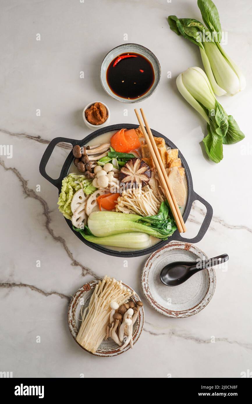 Latte di soia ricetta Hot Pot con cavolo di napa, funghi e maiale affettato sottile cotto in un brodo cremoso e salato di latte di soia. Foto Stock