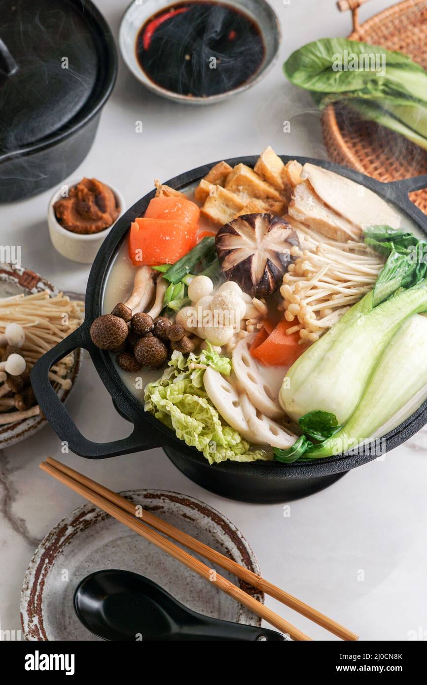 Latte di soia ricetta Hot Pot con cavolo di napa, funghi e maiale affettato sottile cotto in un brodo cremoso e salato di latte di soia. Foto Stock