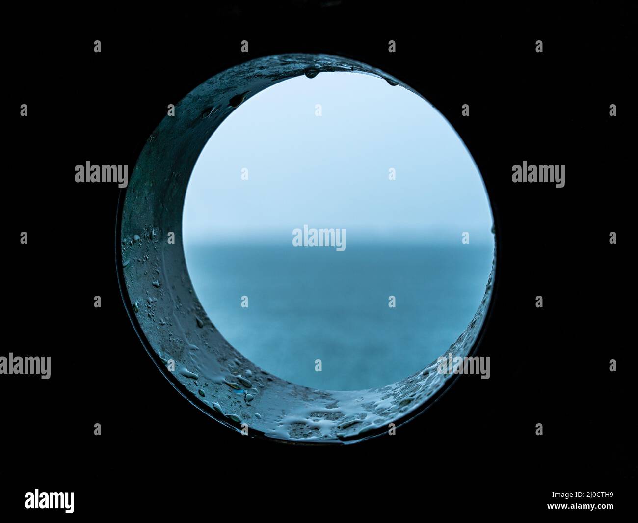 Vista mare tempestosa e piovosa da un porthole in una vecchia barca a vela, Bocas del Toro, Panama Foto Stock