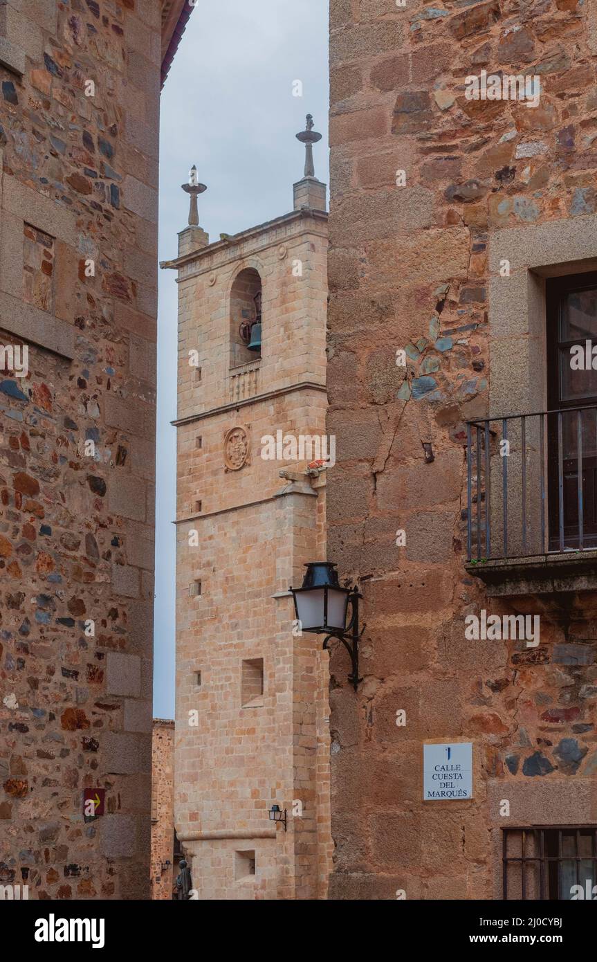 Campanile della cattedrale di Cacares e antiche mura di Calle Cuesta del Marques, Caceres, Extremadura, Spagna Foto Stock