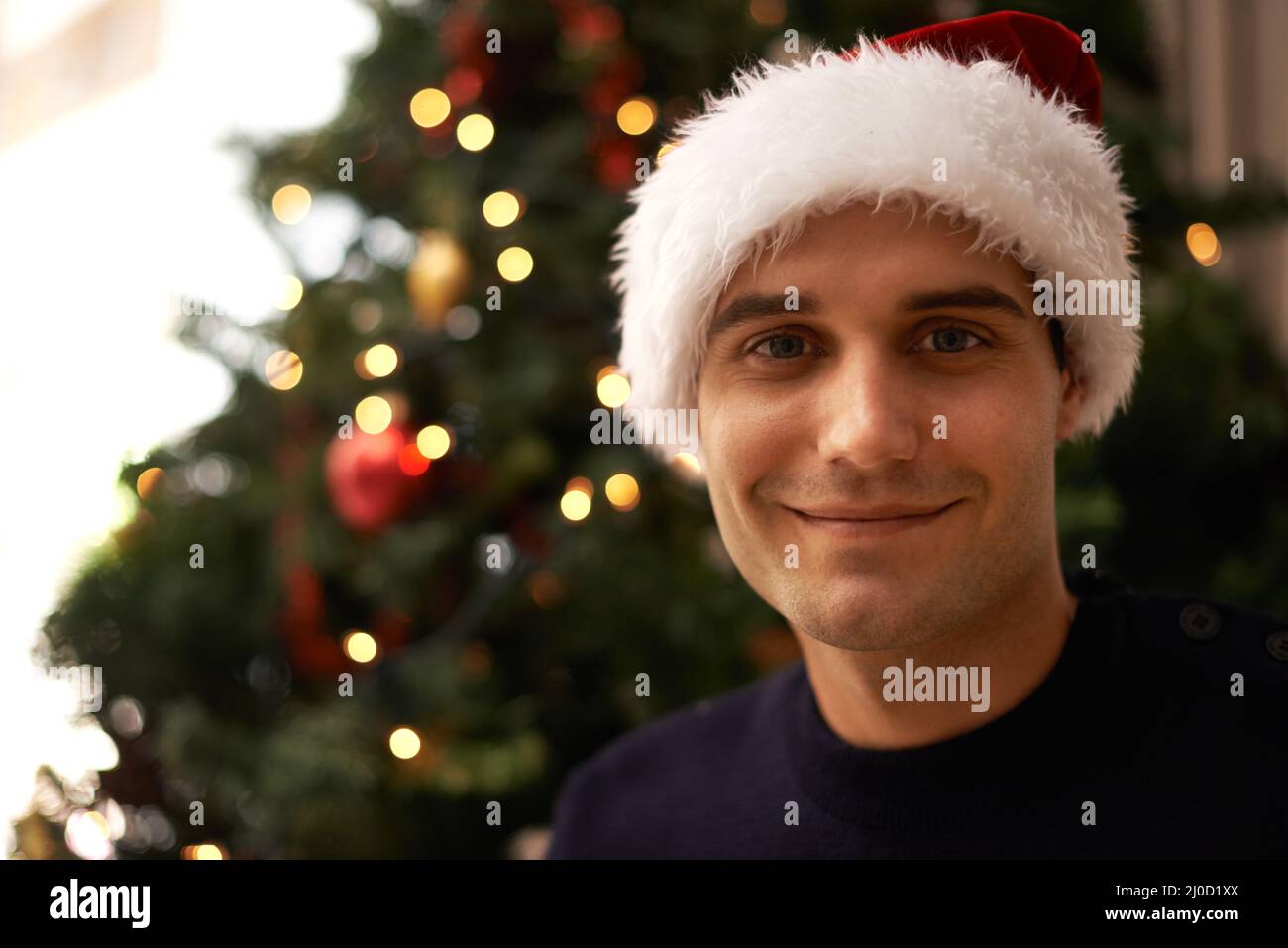 Santas piccolo aiutante. Scatto di un bel giovane uomo che si prepara per Natale. Foto Stock