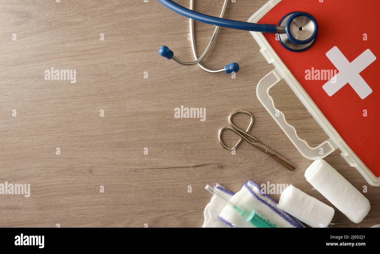 Sfondo con apparecchiature mediche portatili per una rapida assistenza in ospedale su tavolo di legno. Composizione orizzontale. Vista dall'alto. Foto Stock