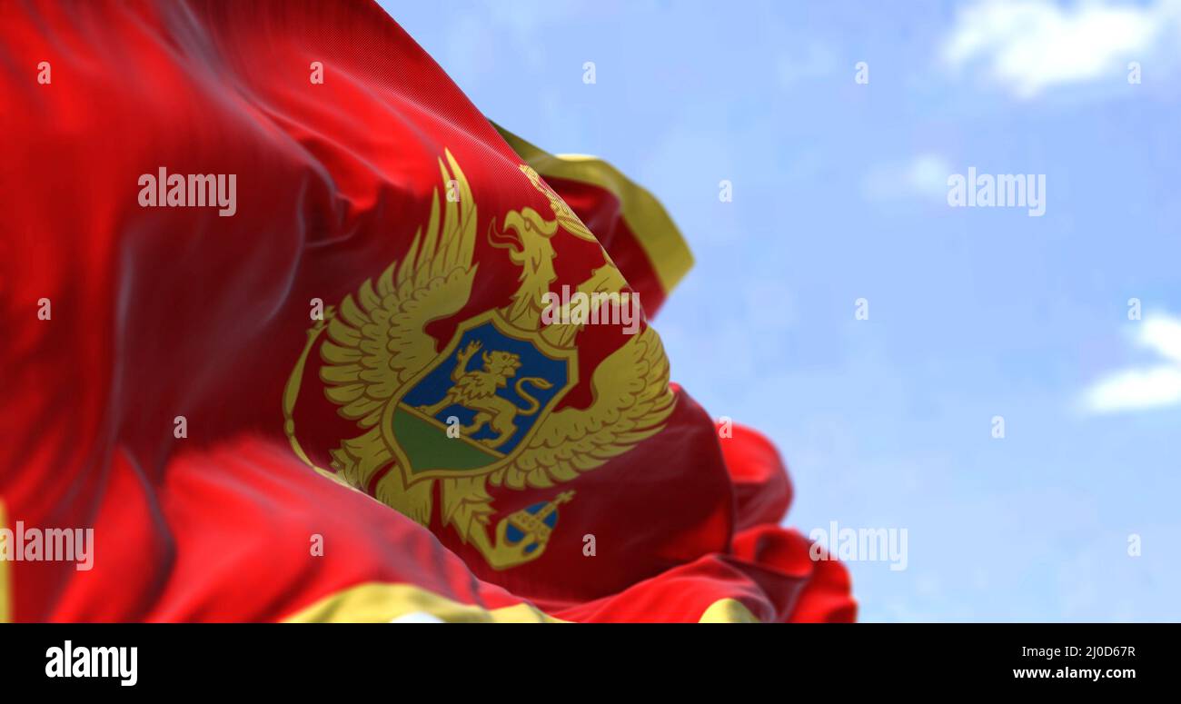 Dettaglio della bandiera nazionale del Montenegro che sventola nel vento in una giornata limpida. Il Montenegro è un paese dell'Europa sudorientale. Messa a fuoco selettiva. Foto Stock