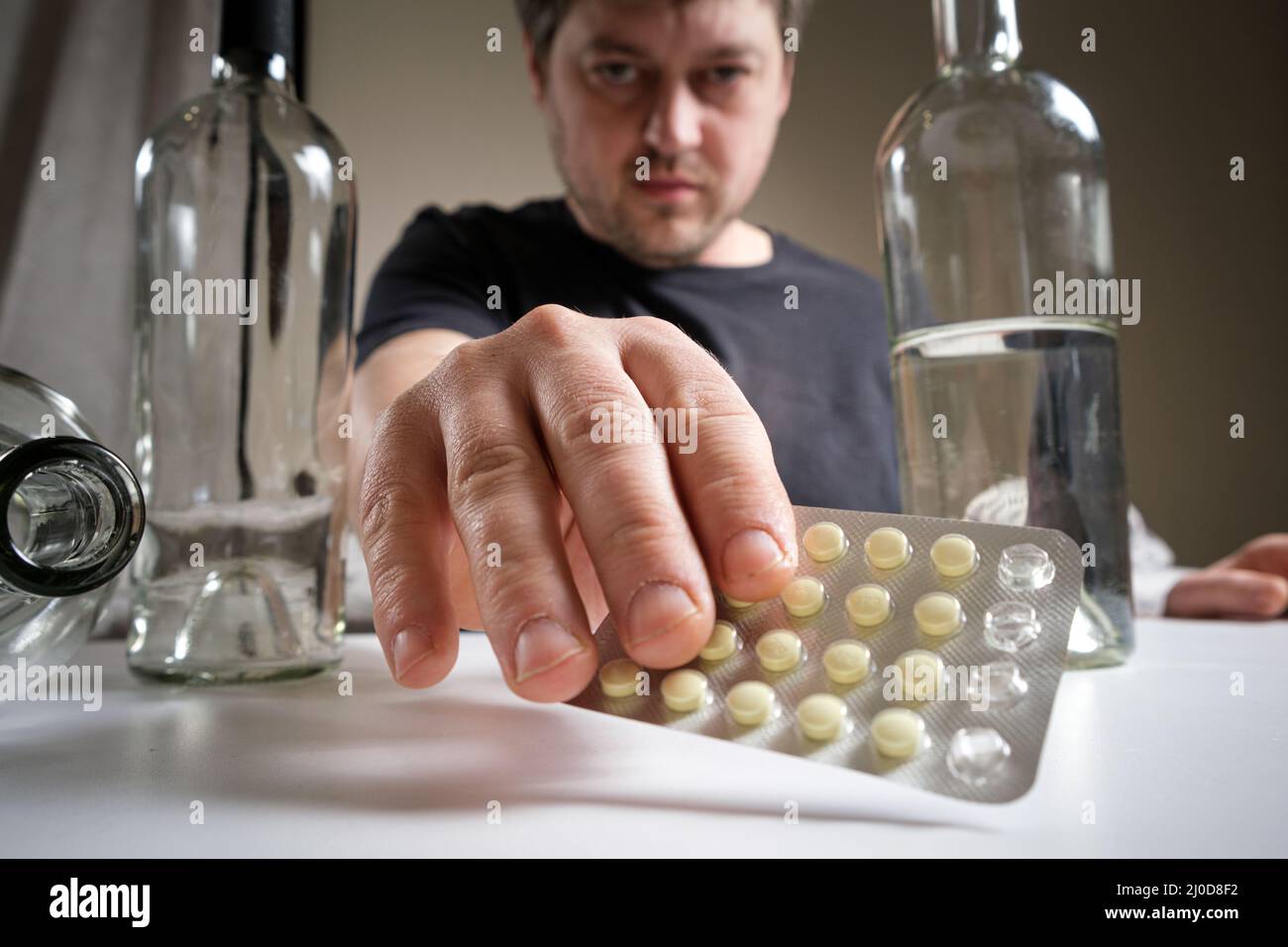 Un uomo mantiene pillole di hangover, trattamento di alcool, dipendenza da alcool Foto Stock