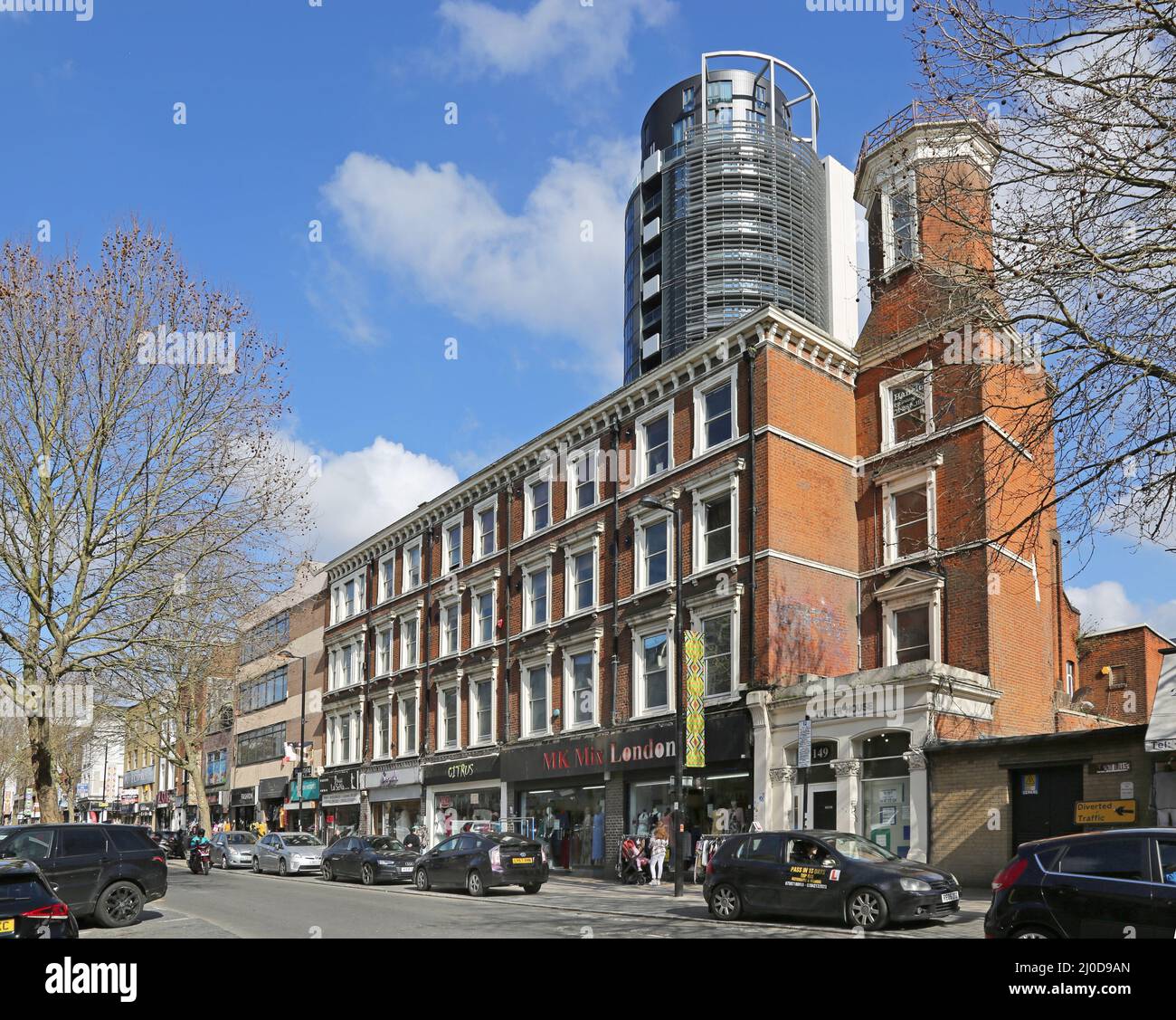 Finsbury Park, Londra, Regno Unito. Negozi su Fonthill Road con torri del nuovo sviluppo residenziale City North sullo sfondo. Foto Stock