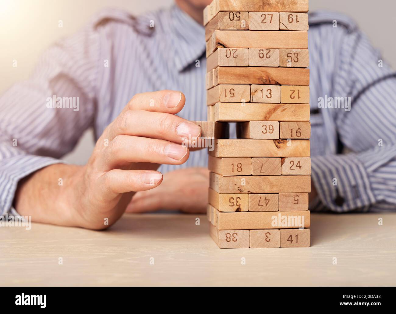 Blocchi di legno torre in uomo d'affari primo piano. Concetto di gestione del rischio finanziario e pianificazione strategica. Foto di alta qualità Foto Stock