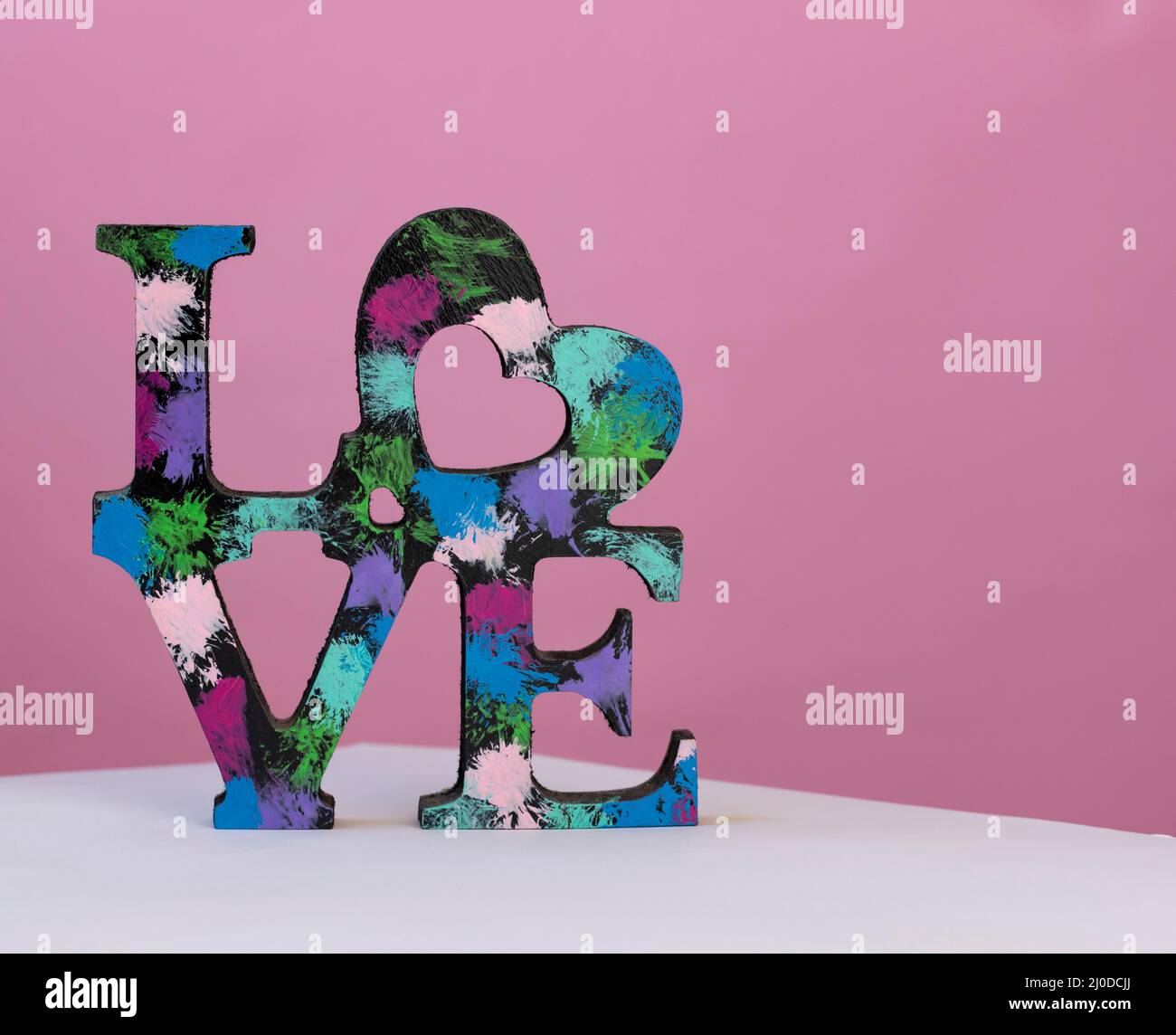 Parola di legno amore su sfondo di colore acceso. Festa della mamma, concetto di San Valentino. Concetto di amore Foto Stock