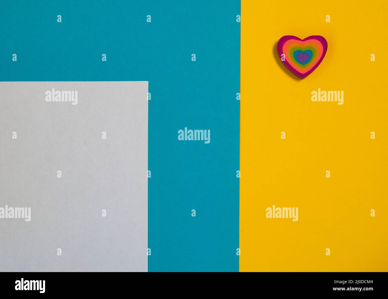 Modello carta San Valentino. Cuore colorato su sfondo blu e giallo. Tessera per il giorno della mamma. Concetto di amore. Spazio di copia Foto Stock