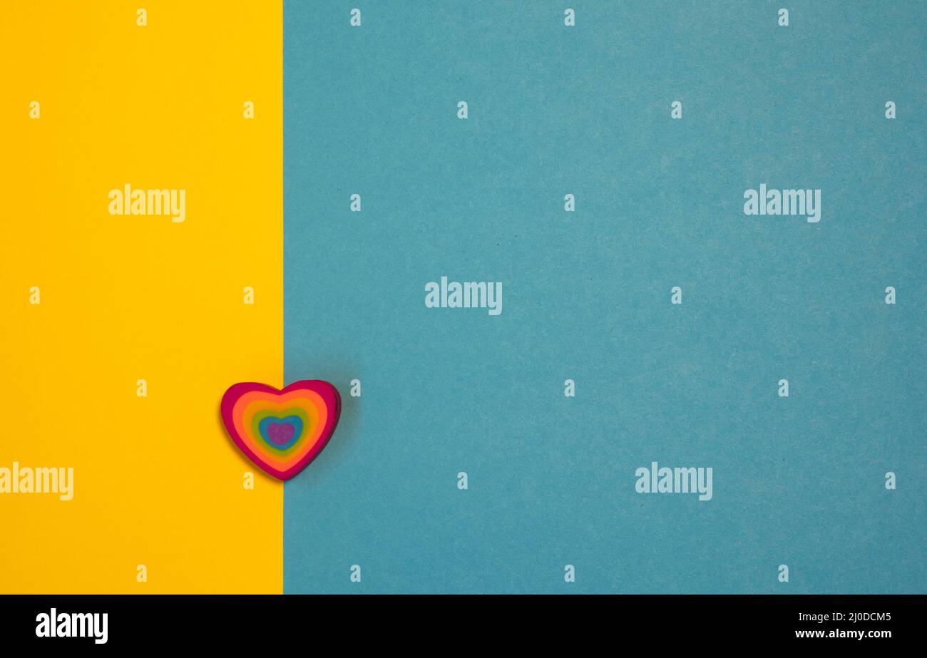 Modello carta San Valentino. Cuore colorato su sfondo blu e giallo. Tessera per il giorno della mamma. Concetto di amore. Spazio di copia Foto Stock