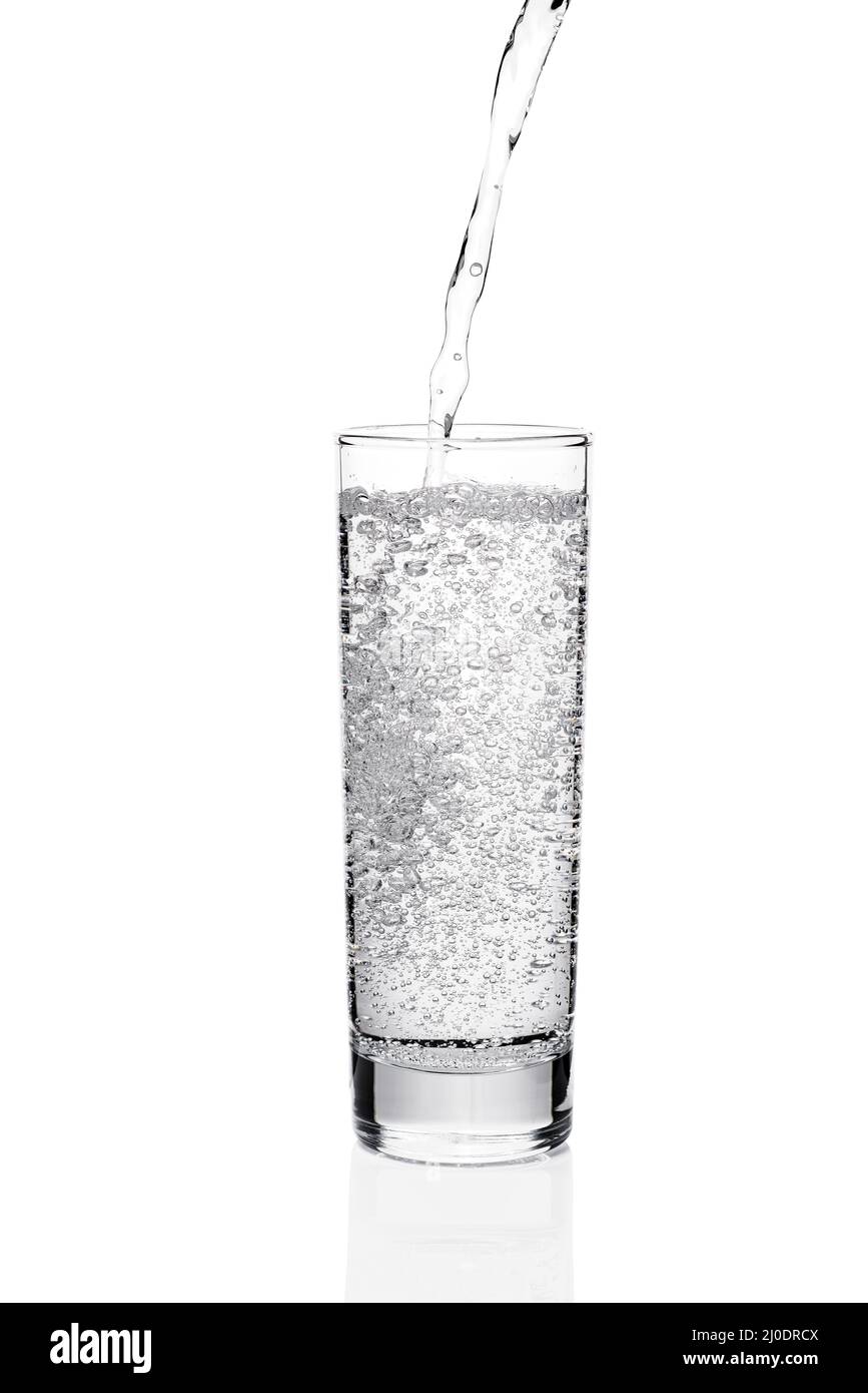 Versando acqua in vetro con bolle Foto Stock