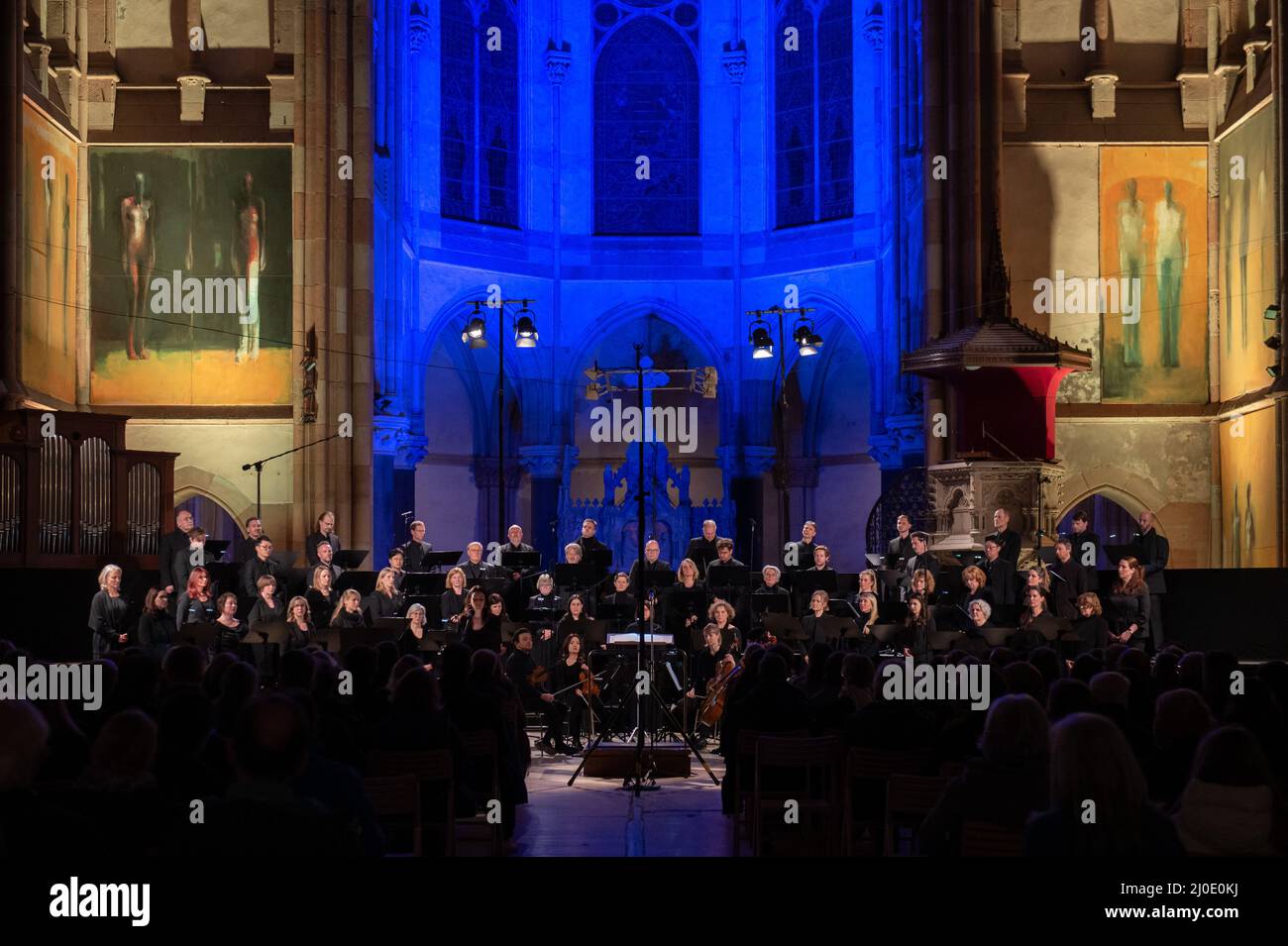 Lipsia, Germania. 18th Mar 2022. Cantanti del coro radio MDR al concerto "··· - Peace", in cui si sentono le preghiere musicali e liriche di pace di cinque secoli nella Chiesa di San Pietro, illuminata nei colori della bandiera Ucraina. A causa della guerra contro l'Ucraina e sullo sfondo dei dibattiti sociali, l'MDR Klassik ha concettualmente riallineato il concerto speciale originariamente previsto per la fiera del libro. Credit: Christian Modla/dpa/Alamy Live News Foto Stock