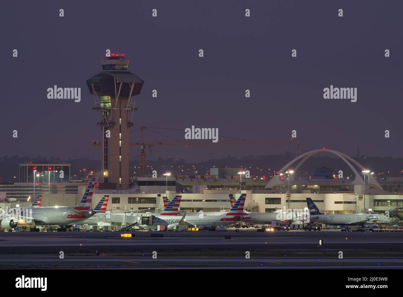 Aeroporto internazionale di Los Angeles, LAX, inclusi l'edificio a tema e la torre di controllo mostrata al crepuscolo. Foto Stock