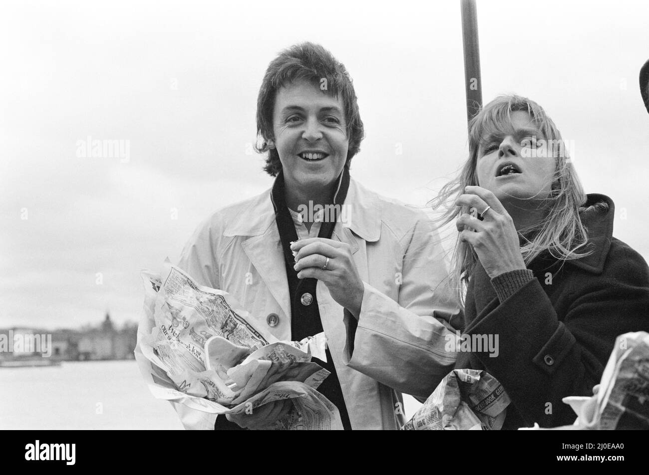 Paul McCartney e sua moglie Linda del gruppo pop Wings che naviga lungo il Tamigi insieme a Denny Laine (non in questa cornice) Mentre i tre di loro promuovono il nuovo singolo della band 'Wittle Luck' dal nuovo album 'London Town'.Vegetatians Paul and Lind godendo una porzione di chips. Foto scattata il 22nd marzo 1978. Foto Stock