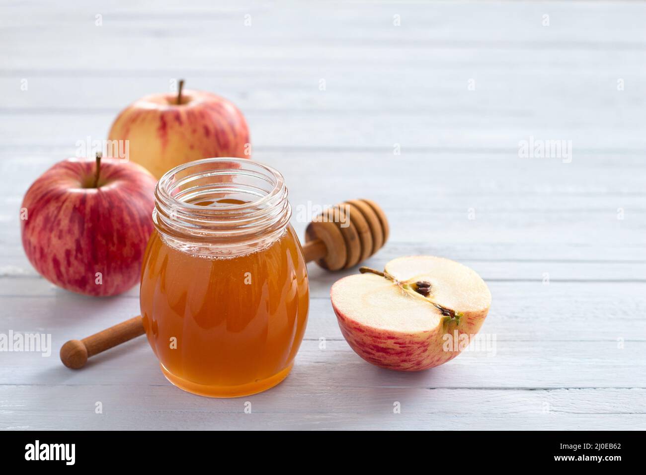 Mele e miele su sfondo ligneo per il nuovo anno ebraico rosh hashanah Foto Stock