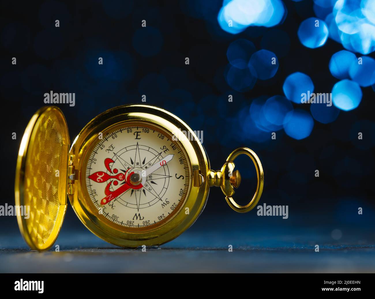 Orologio d'oro antico. Isolato su sfondo blu scuro. Simbolo del tempo, vecchia cosa. Bella composizione. Non ci sono persone nella foto. Pubblicitàin Foto Stock