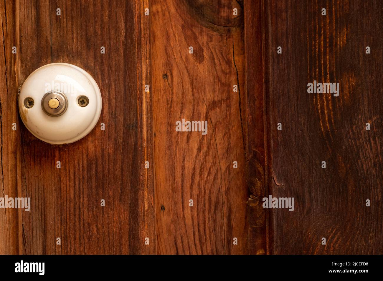 Antico campanello bianco su una porta di legno Foto Stock