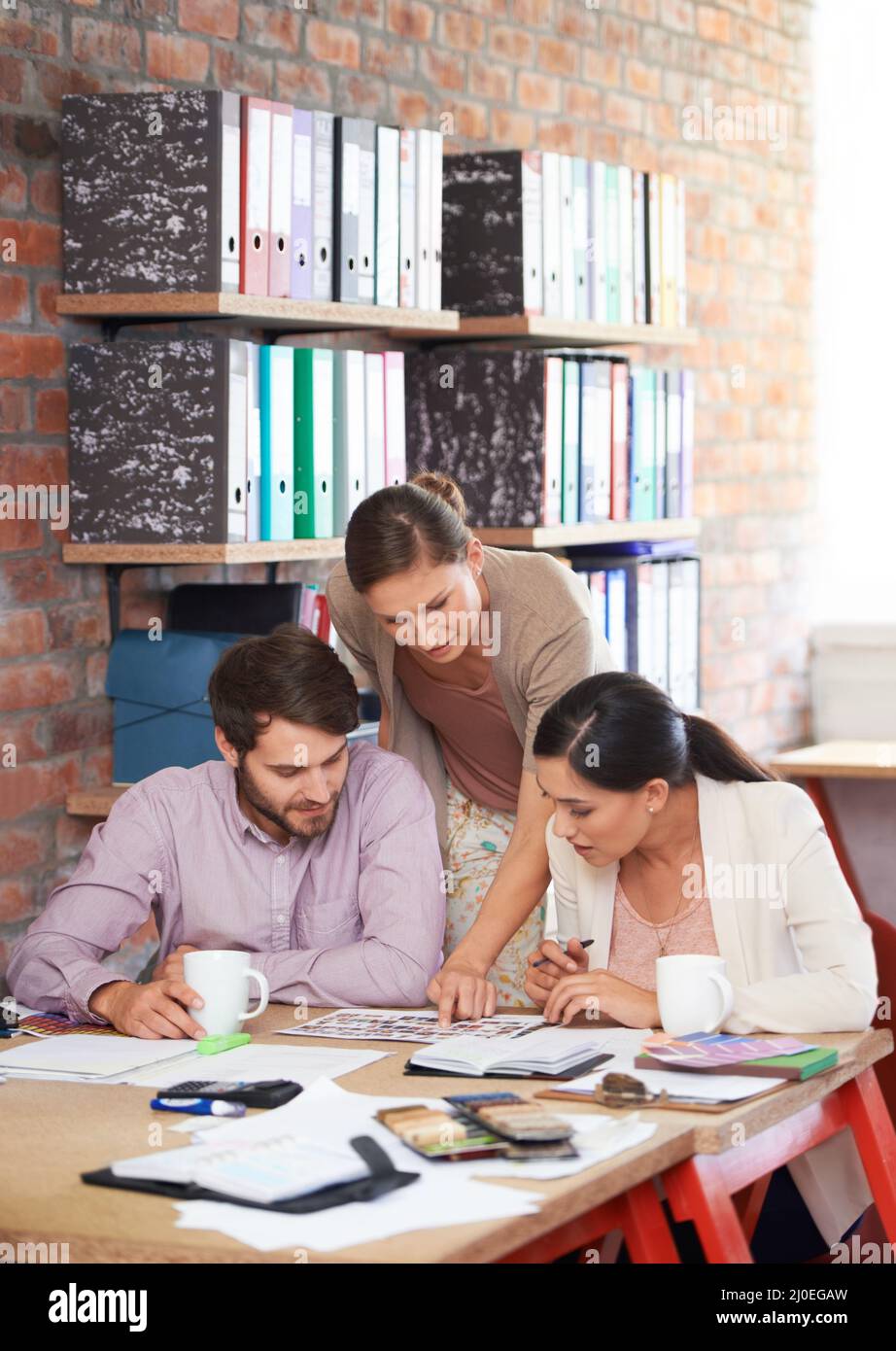 Attraverso ogni dettaglio. Giovani professionisti creativi che lavorano in ufficio. Foto Stock
