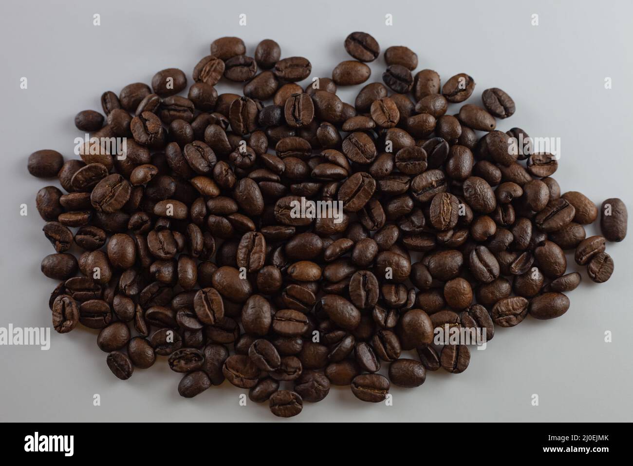 Chicchi di caffè tostati su sfondo bianco Foto Stock
