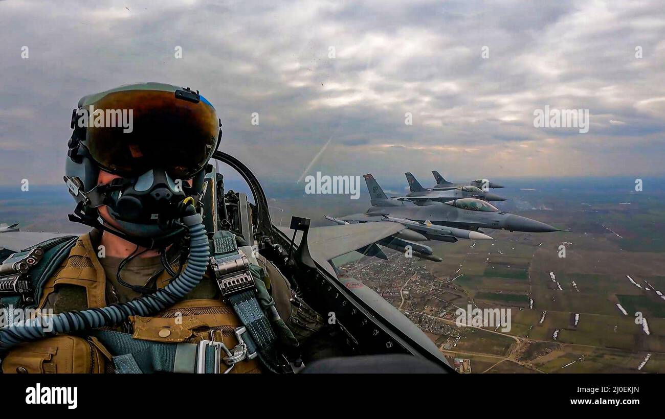 Due aerei da combattimento Falcon dell'Aeronautica militare statunitense F-16 assegnati allo Squadrone combattente Expeditionary Fighter del 480th alla base aerea di Spangdahlem, Germania, volano accanto a due F-16s rumeni sopra la Romania, 14 marzo 2022. Gli aerei si allenano regolarmente con i partner e gli alleati della NATO per garantire sicurezza e stabilità all'interno del teatro europeo. (STATI UNITI Air Force foto di Senior Airman Ali Stewart) Foto Stock