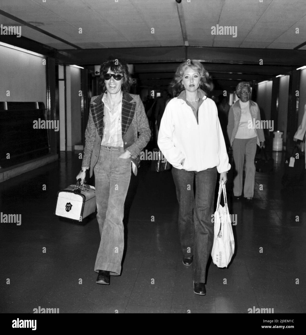 Bill Wyman delle 'Rolling Stones' arrivando all'aeroporto di Heathrow da Barbados, con la sua ragazza Astrid Lundstrom, dove sono stati in vacanza. Marzo 1978 78-1325 Foto Stock