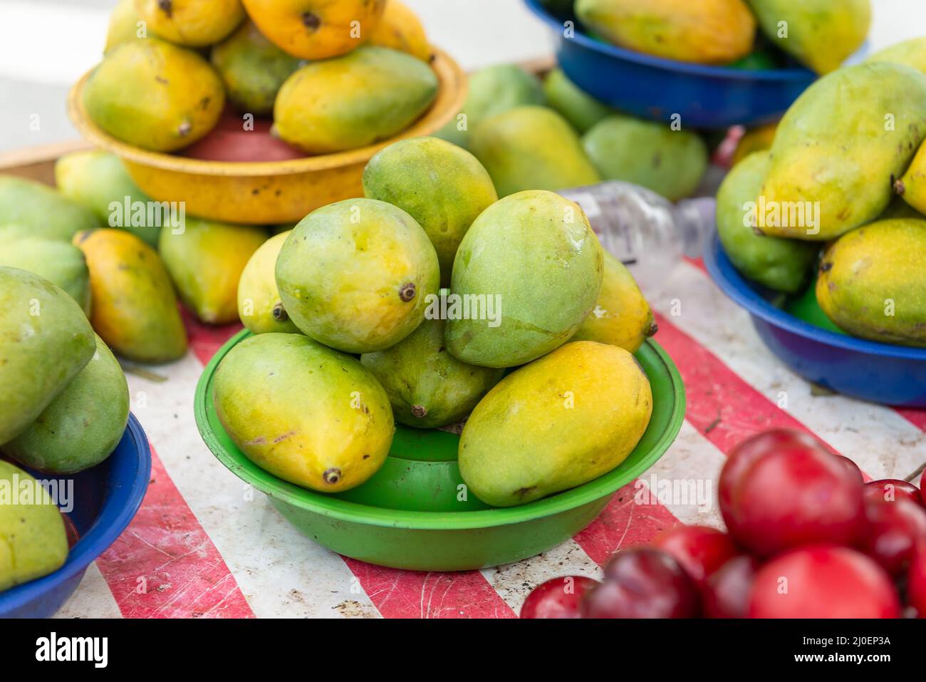 Mango e prugne accatastate al mercato di strada Foto Stock