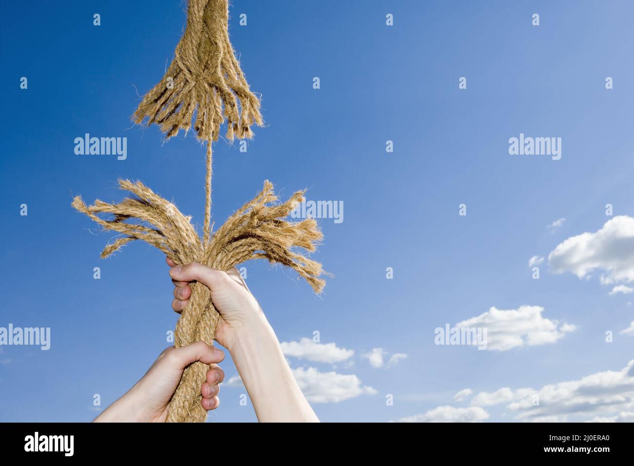 Un uomo che tiene su una corda sfrangiante Foto Stock