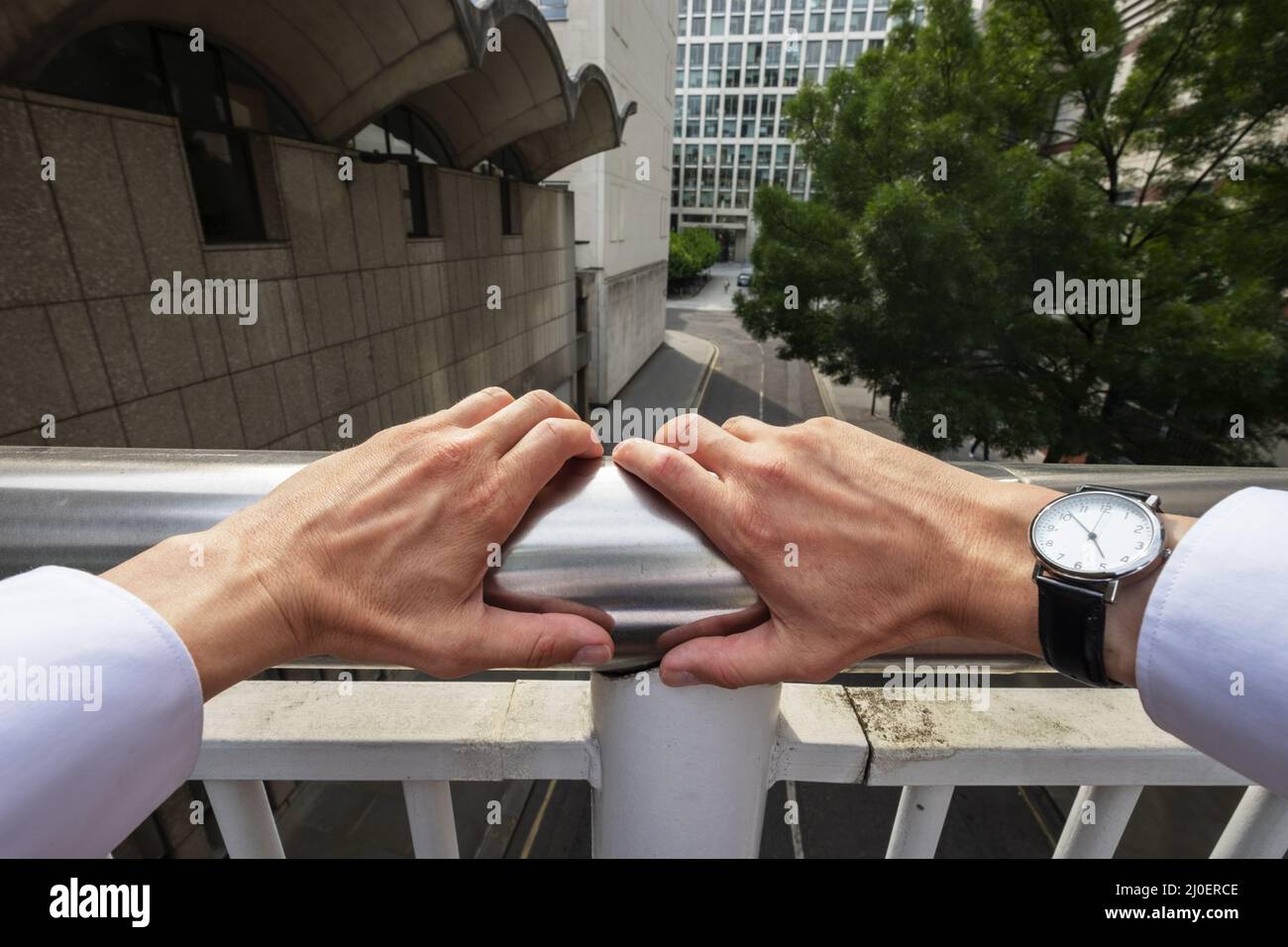 La prospettiva personale di un uomo d'affari che poggia su ringhiere Foto Stock
