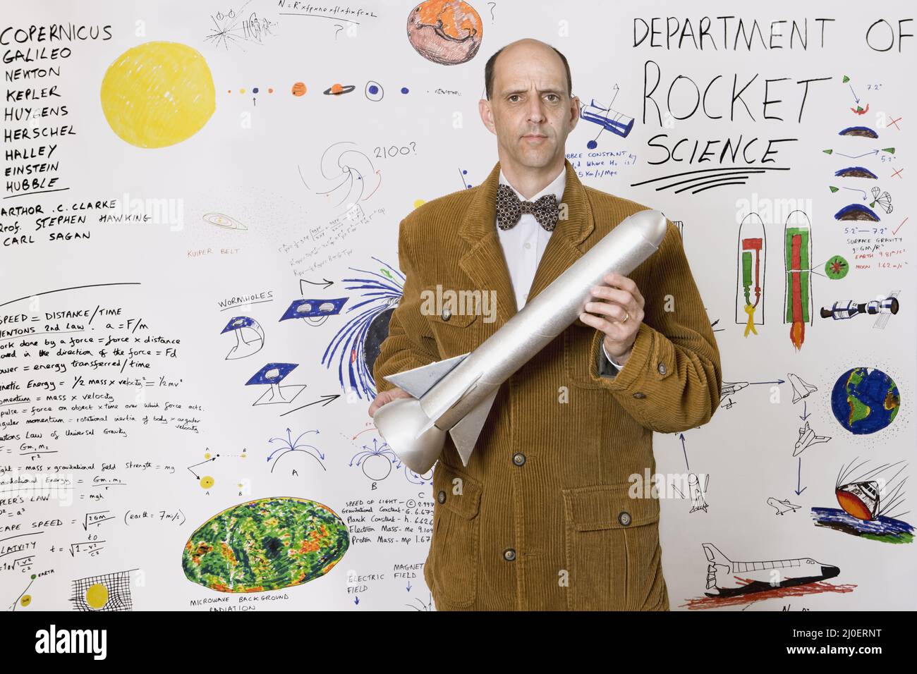 Scienziato caucasico di mezza età di razzo in piedi di fronte ai disegni astronomici sul reparto di parete di Foto Stock