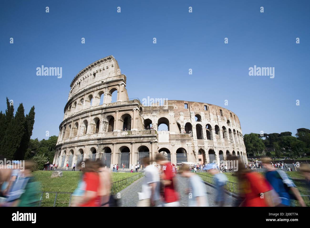 I turisti che passeggiavano davanti al Colosseo durante il giorno. Roma. Italia. Foto Stock