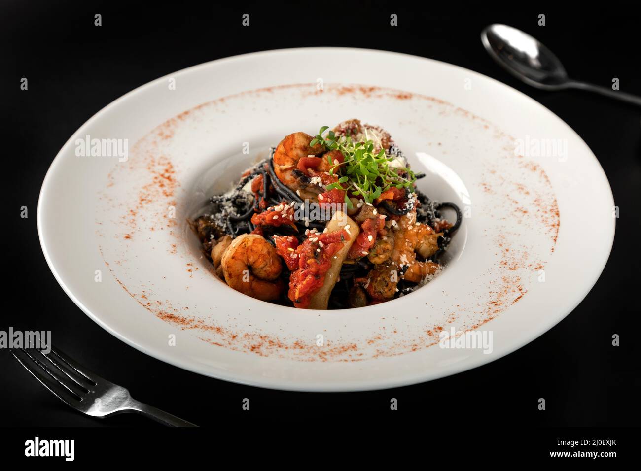 Pasta nera con inchiostro di calamari, con carne di calamari, granchio, gamberi e pesce. Foto Stock