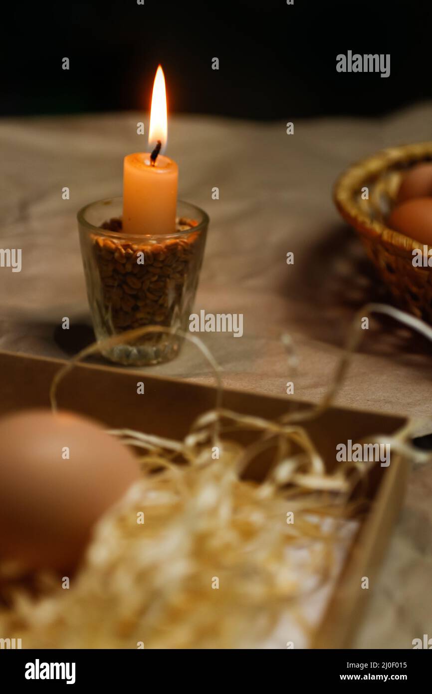 Candela con luce. Sfondo rustico. Strumenti per la decorazione delle uova pasquali, Pysankas. Raccolta uova. Penna fatta in casa per disegnare uova. Preparazione per Foto Stock