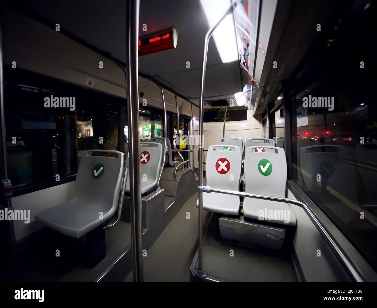 All'interno di un autobus di trasporto pubblico con posti a sedere vuoti con l'indicazione di dove è possibile sedersi Foto Stock