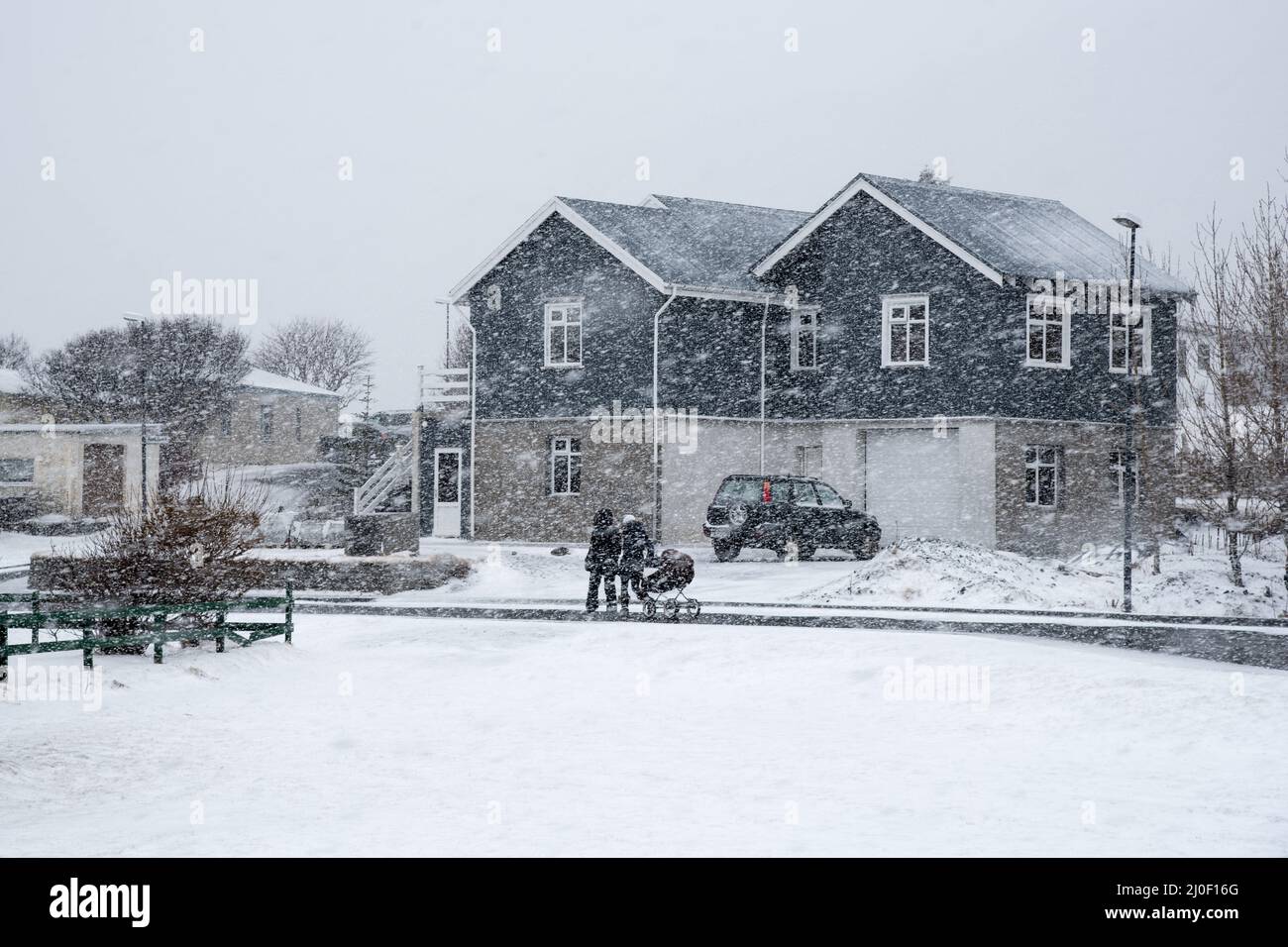 Famiglia non riconosciuta con bambini che camminano durante la tempesta di neve pesante. Vik , Islanda Foto Stock