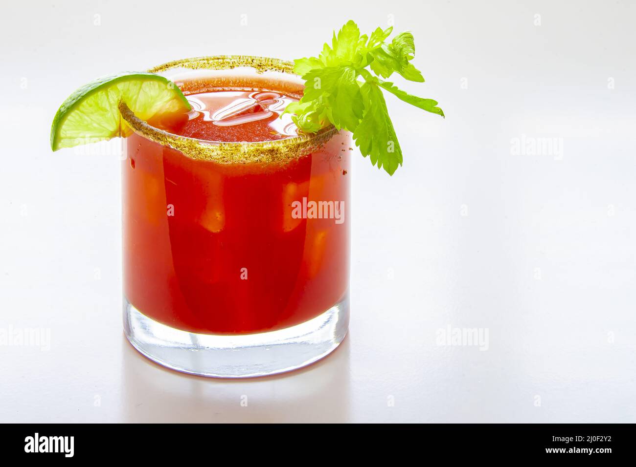 Primo piano di un cocktail freddo caesar o di una sanguinosa mary su un bicchiere su sfondo bianco Foto Stock