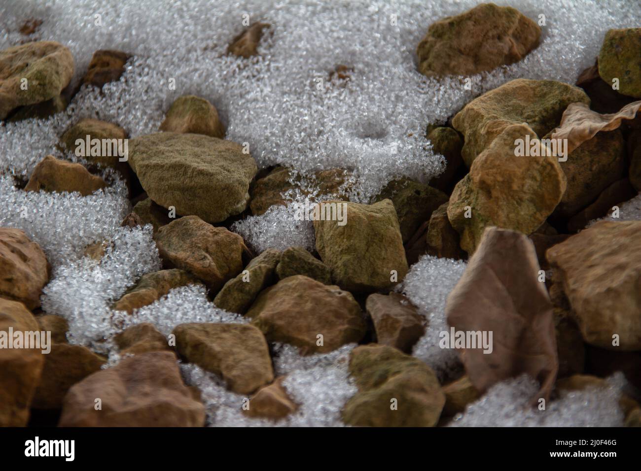 Trama astratta sfondo di neve bianca che copre tan colore schiacciato roccia paesaggistica, con spazio copia Foto Stock