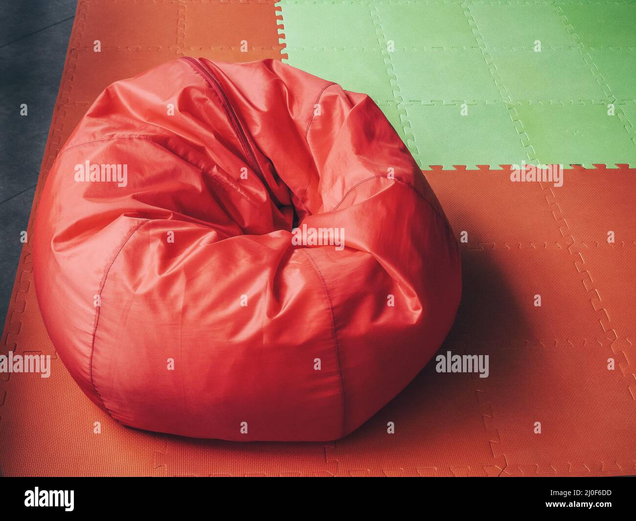 Borsa rotonda rossa morbida sul pavimento verde rosso Foto Stock