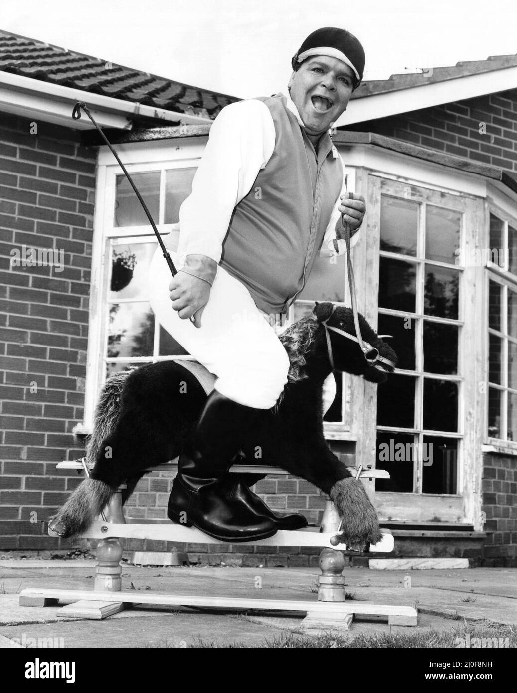 Una foto di una serie di immagini di novità umuristiche scattate dal fotografo domenicale Dennis Hutchinson. - Il giocatore di freccette Jocky Wilson si diverte su un cavallo a dondolo. Foto Stock