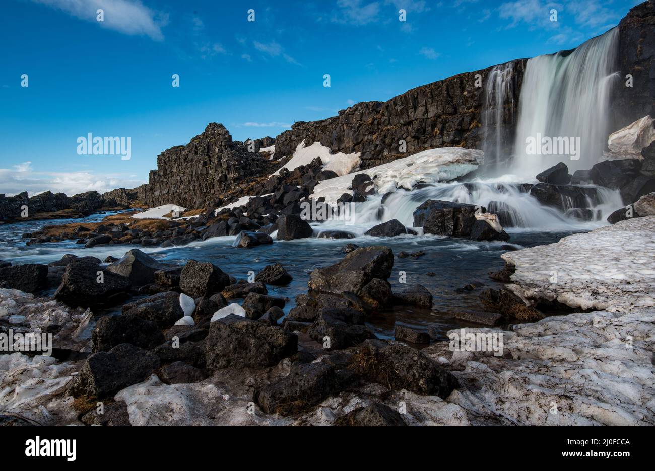 Acqua dalla cascata che spruzzi su un fiume roccioso Islanda Foto Stock