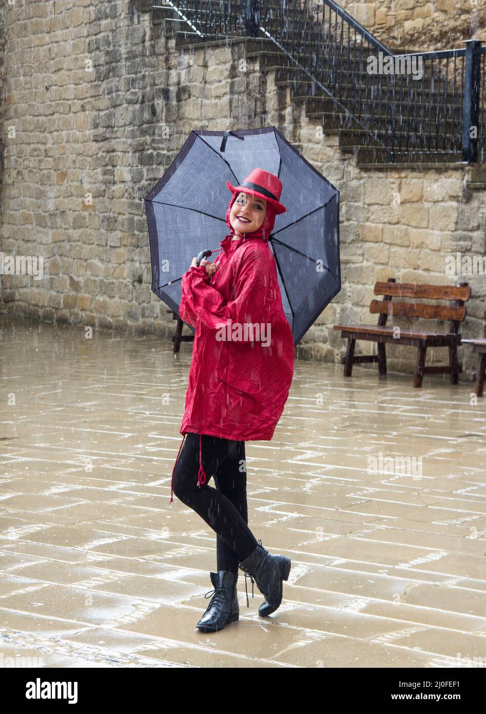 Giovane donna in piedi sotto la pioggia Foto Stock