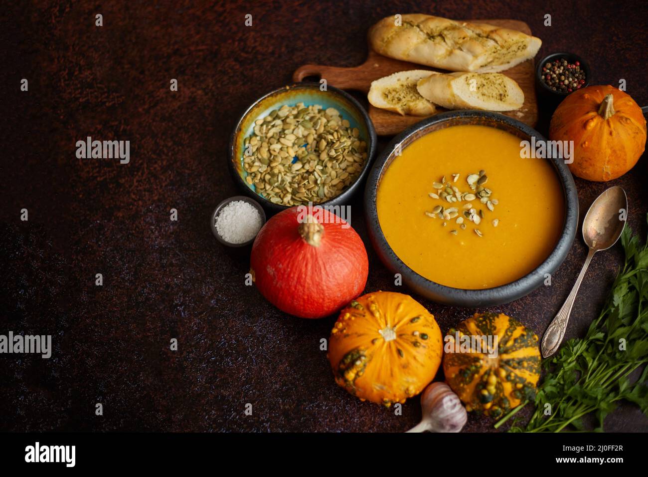 Zuppa di crema di zucca vegetariana fatta in casa servita in ciotola di ceramica. Decorato con semi Foto Stock